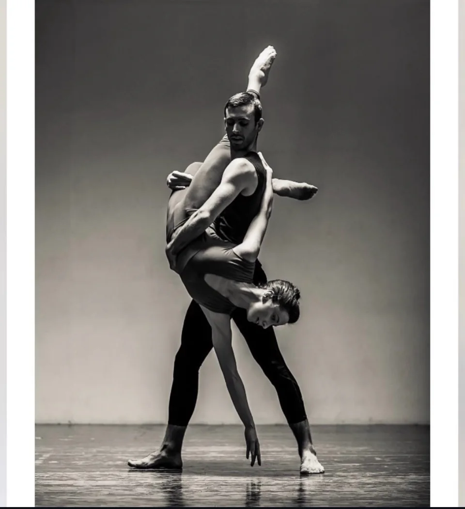 Amy held in an inverted lift by a dance partner, photographed in black and white